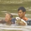 眼見車子被洪水吞噬，英勇暖男跳入水中救出了女駕駛，並再回頭救出駕駛的愛犬！